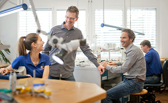 Mitarbeiter eines Dentallabors arbeiten in einer guten Atmosphäre